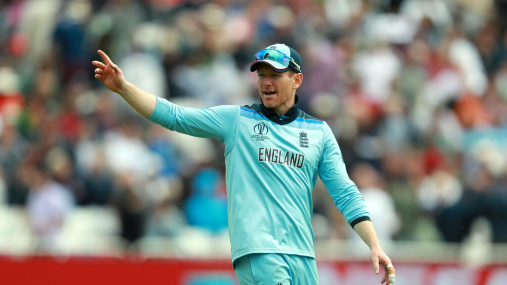 Eoin Morgan leading England cricket team in light blue kit focused during intense match action Wallpaper