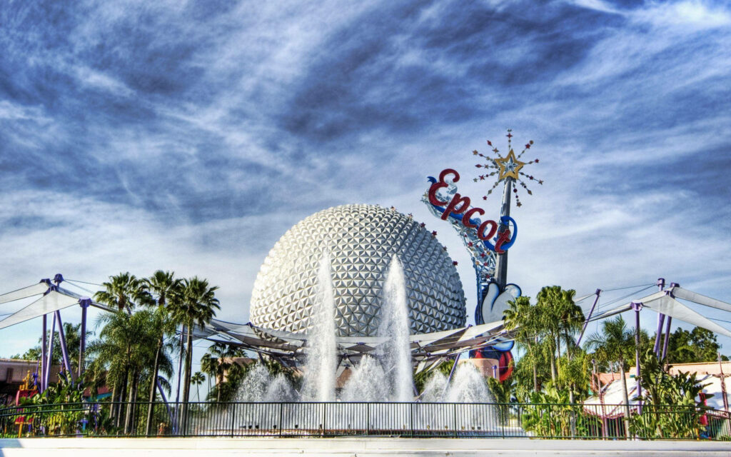 Vibrant Epcot geodesic sphere with colorful sign fountain lush greenery and clear blue sky wallpaper