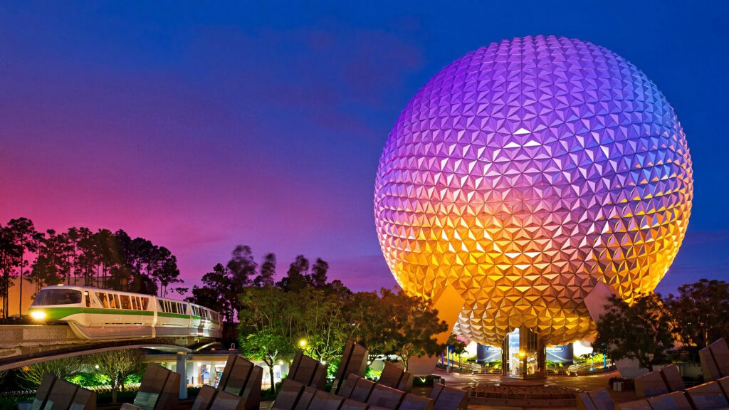Epcot Globe illuminated with purple orange yellow gradient and monorail at night wallpaper background