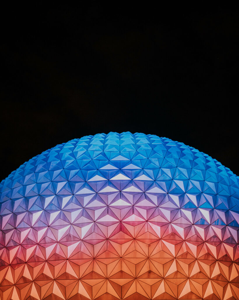 Epcot globe wallpaper with vibrant orange and blue gradients on black futuristic background
