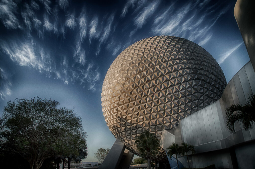 Epcot Globe wallpaper with metallic geometric patterns under moody dark blue sky and clouds