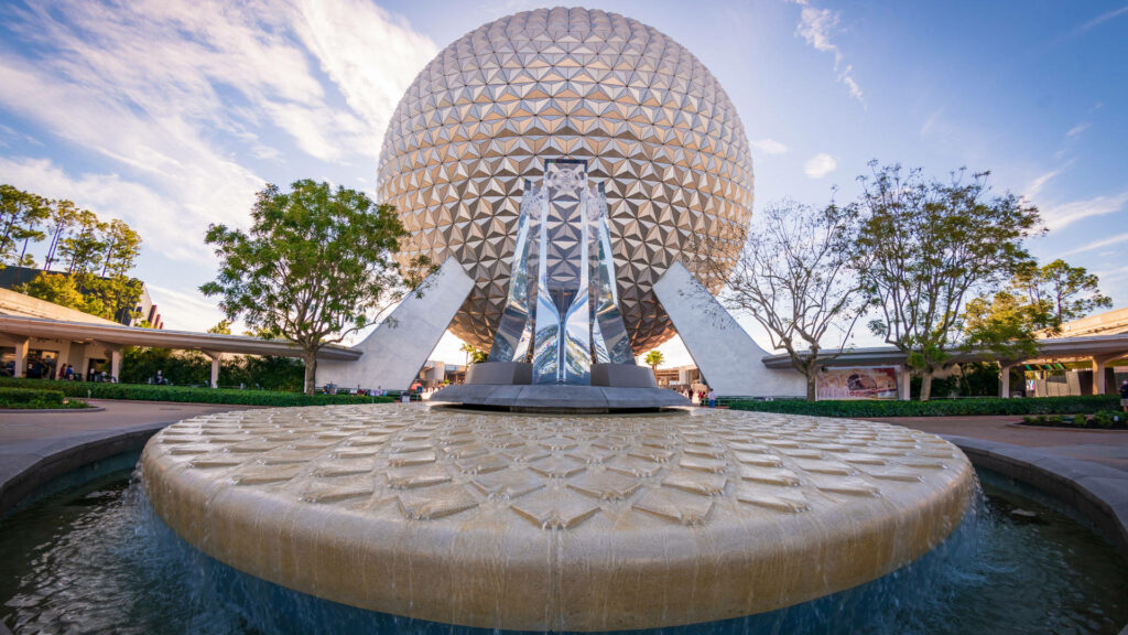 Vibrant Epcot Globe wallpaper with geometric patterns fountain bright sky and lush greenery background
