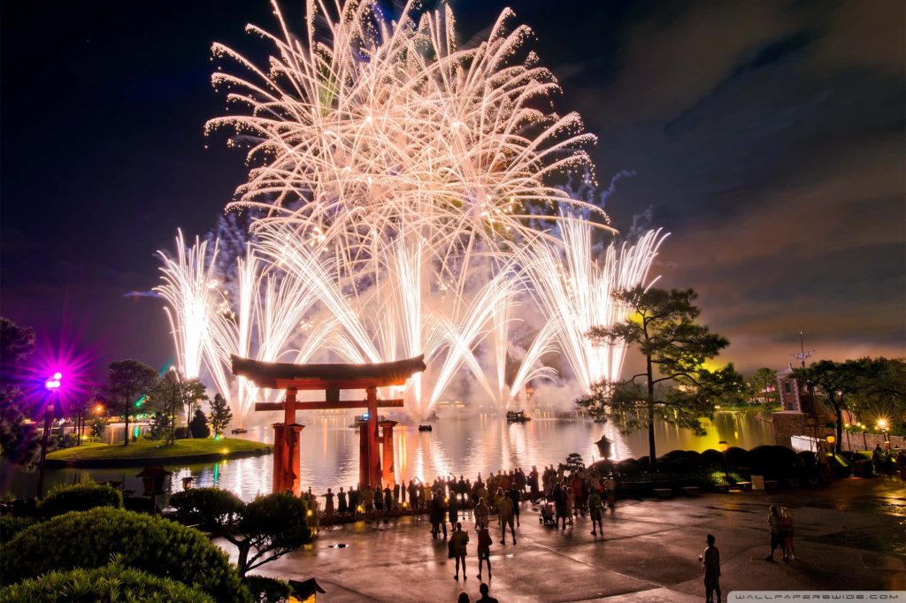 Red Torii gate at Epcot Japan Pavilion with vibrant lagoon fireworks and festive crowd at night Wallpaper