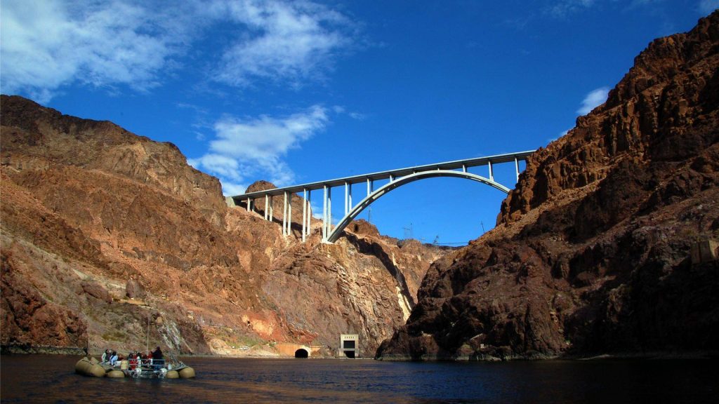 Tourists rafting Colorado River Black Canyon beneath Mike O'Callaghan Pat Tillman Bridge Wallpaper