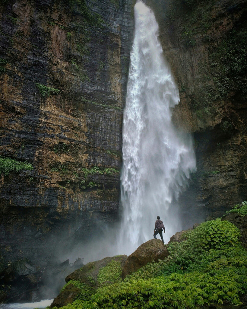 Nature's Power: Majestic Waterfall Wallpaper with Brave Individual