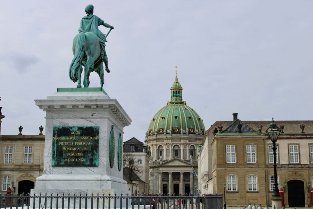 Equestrian statue at Amalienborg Palace Square with grand dome and classical architecture background Wallpaper