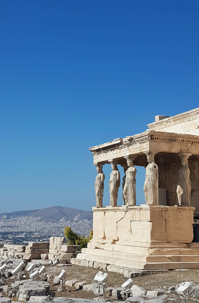 Erechtheion eastern view with Caryatids overlooking Athens cityscape under clear blue sky wallpaper