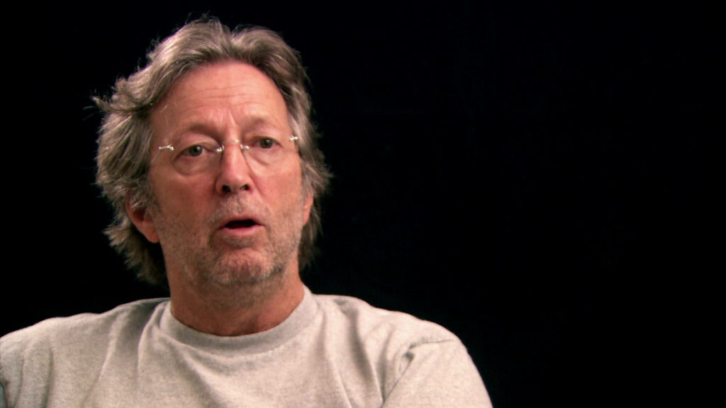 Eric Clapton candid interview portrait relaxed thoughtful expression dark wallpaper background