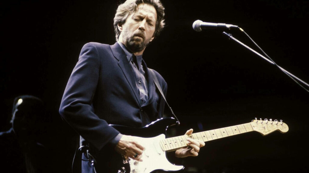 Eric Clapton playing electric guitar on stage eyes closed soft lighting passion wallpaper background