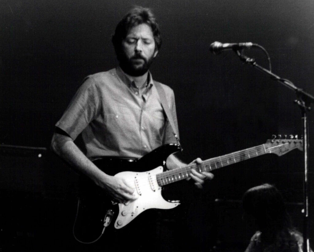 Eric Clapton playing electric guitar in recording studio fully immersed in music creation Wallpaper