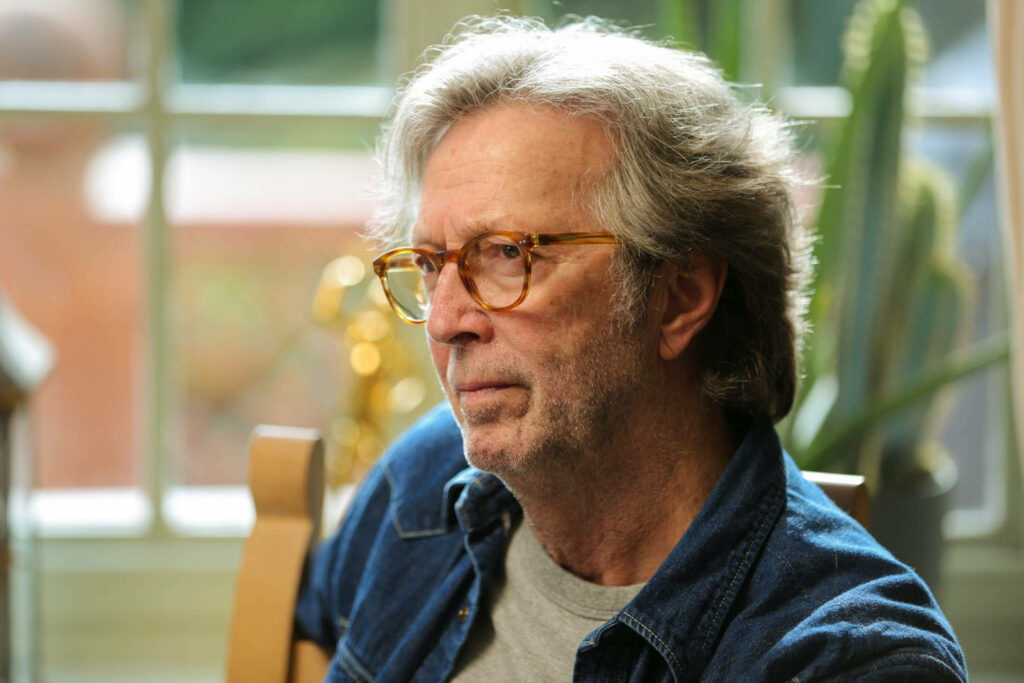 Side profile of Eric Clapton in soft indoor light showcasing his signature style wallpaper