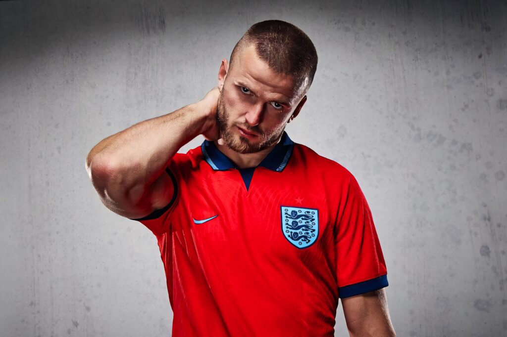 Eric Dier England footballer portrait in red jersey intense expression textured gray background Wallpaper