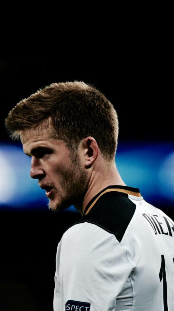 Close-up of footballer Eric Dier in action with dramatic lighting and intense focused expression Wallpaper