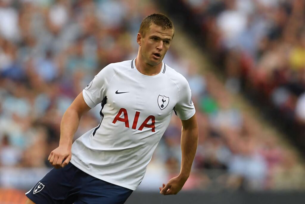 Eric Dier in white Tottenham Hotspur kit focused on action with blurred stadium crowd background Wallpaper