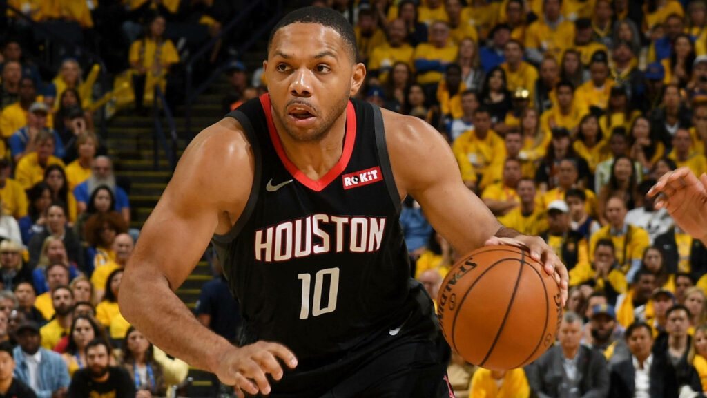 Eric Gordon dribbling for Houston Rockets in intense basketball game with vibrant crowd background Wallpaper