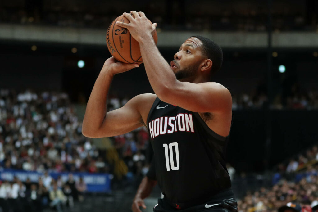 Eric Gordon Houston Rockets shooting basketball mid-action in black jersey with blurred crowd background Wallpaper