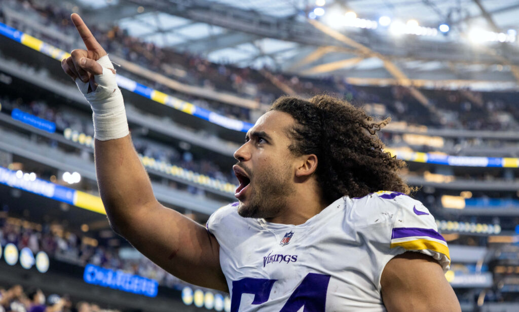 Eric Kendricks in Minnesota Vikings uniform celebrating on field with stadium background wallpaper