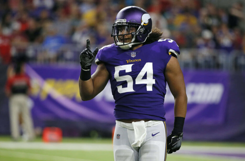 Eric Kendricks Minnesota Vikings linebacker in purple gold uniform raising finger on football field Wallpaper
