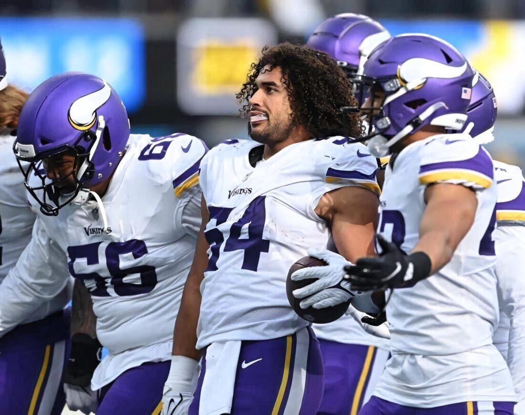 Eric Kendricks leading Minnesota Vikings teammates in purple gold uniforms high resolution wallpaper