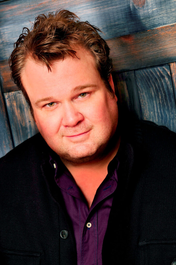 Eric Stonestreet portrait wallpaper warm rustic blue wood background charismatic expression