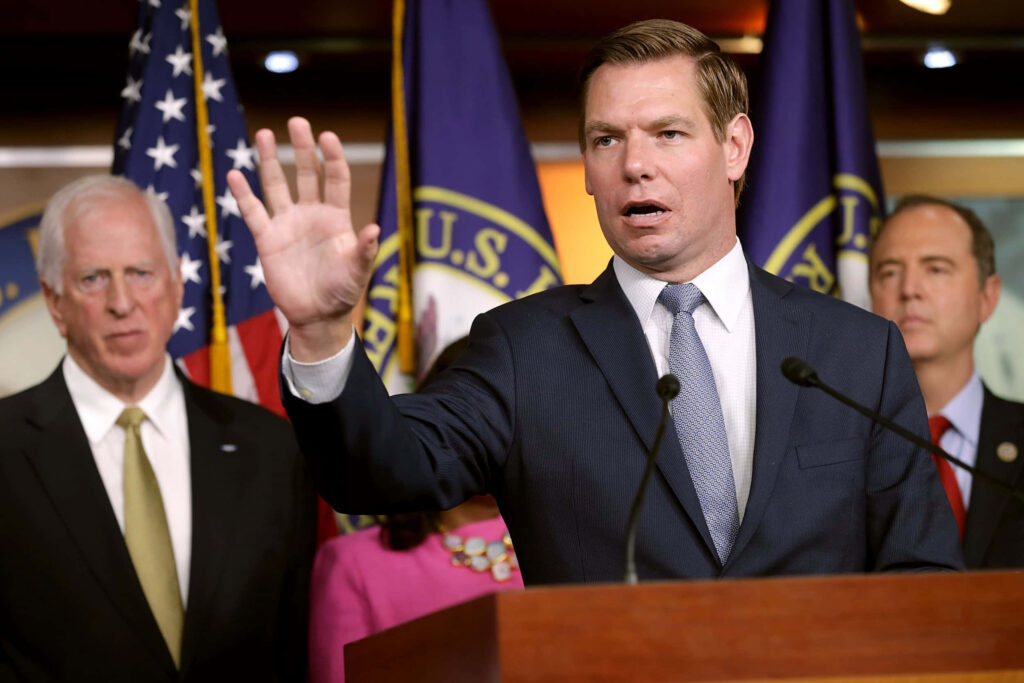 Eric Swalwell speaking at podium in formal press conference with U.S. flags and officials background Wallpaper