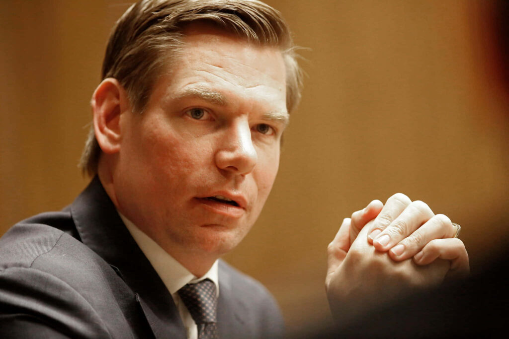 Close-up portrait of Eric Swalwell in dark suit with thoughtful expression and clasped hands Wallpaper