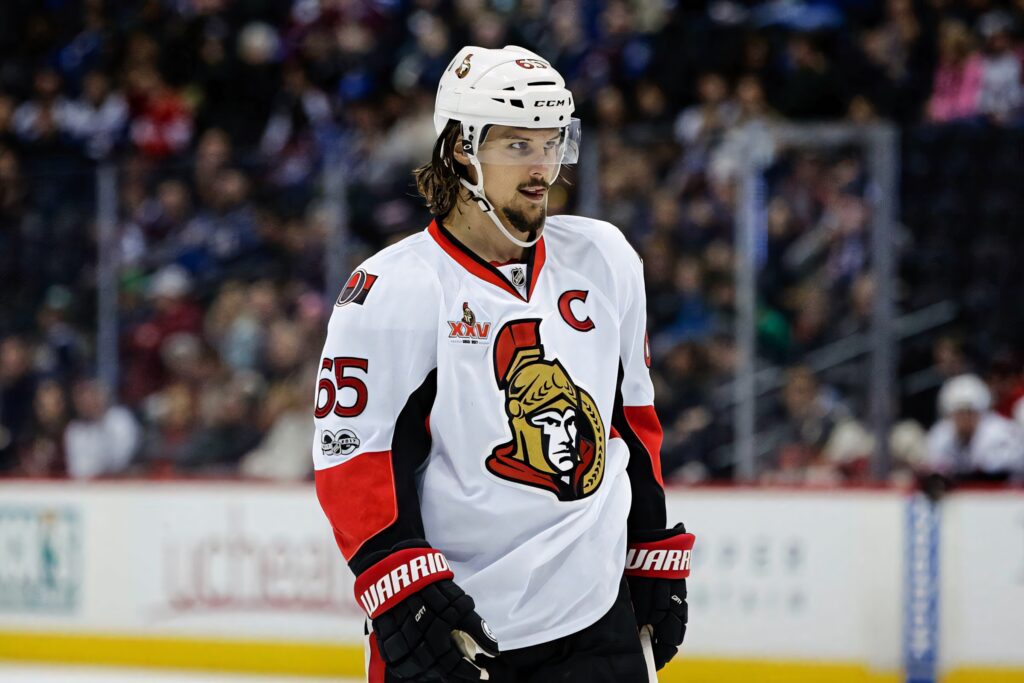 Erik Karlsson Ottawa Senators captain in white jersey on intense ice hockey rink wallpaper background