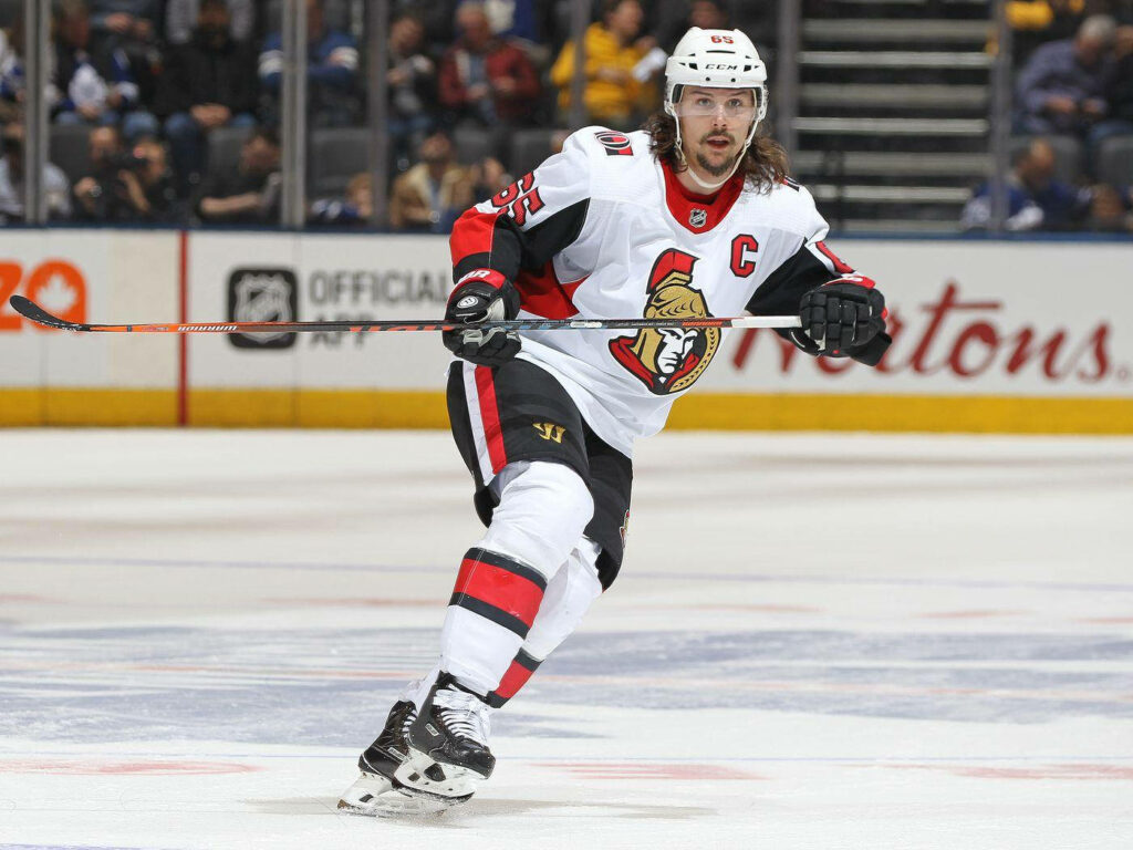 Erik Karlsson Ottawa Senators captain in white jersey skating with focus during live hockey game Wallpaper