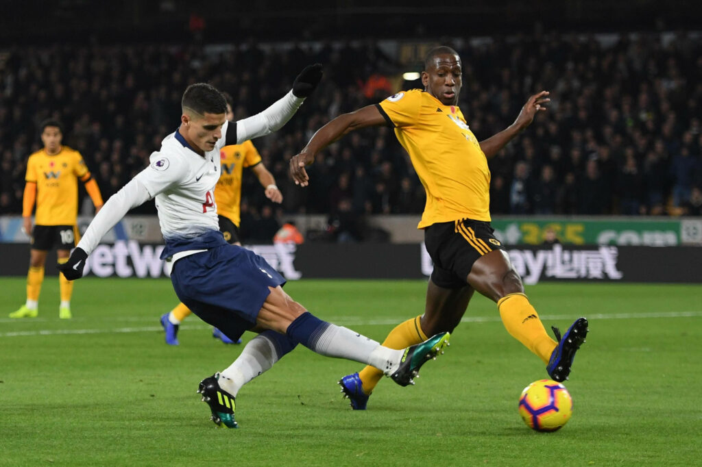 Érik Lamela Tottenham and Willy Boly Wolves in intense football duel vibrant stadium action scene Wallpaper
