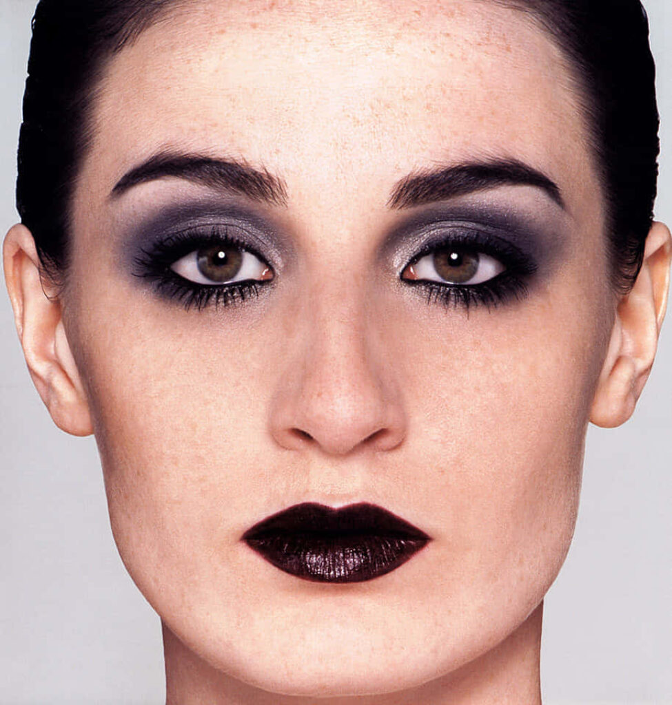 Erin OConnor close-up portrait with bold dark lips smokey eyeshadow minimalist gray background Wallpaper