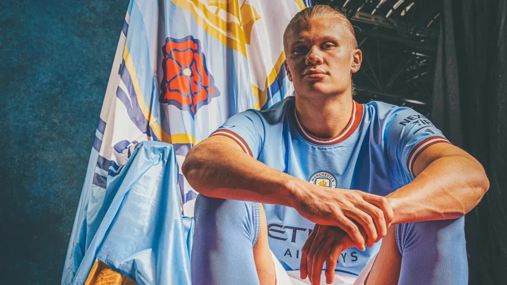 Welcome to the City: Erling Haaland Unveiled as Manchester City's Newest Star - QHD Wallpaper featuring the Iconic Manchester City Logo
