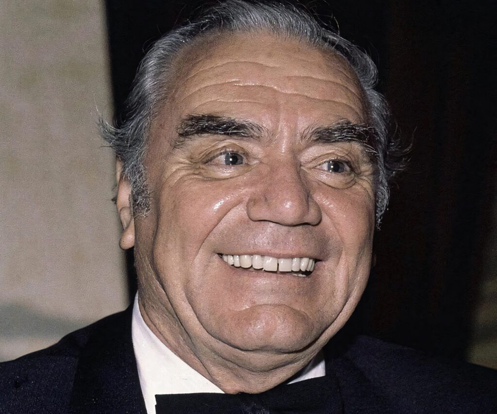 Vibrant portrait of Ernest Borgnine smiling in formal attire classic cinema wallpaper background