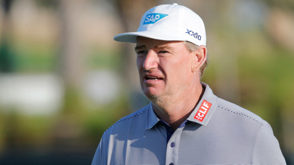 Ernie Els focused golf close up wearing white cap branded sportswear outdoor blurred background Wallpaper