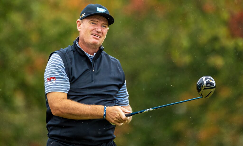 Ernie Els mid-swing on vibrant golf course in classic attire showing focus and confidence Wallpaper