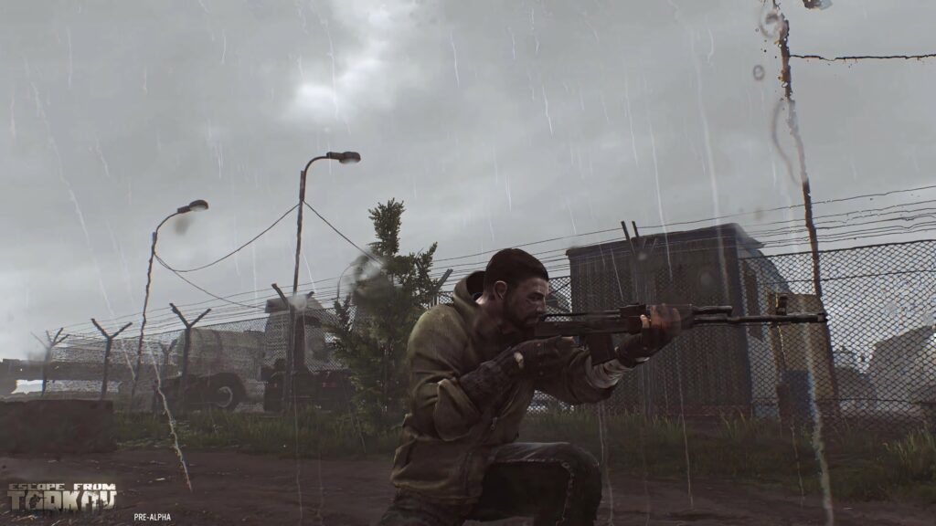 Escape from Tarkov survivor aiming rifle in rainy industrial setting with barbed wire fence Wallpaper