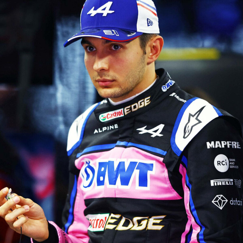 Esteban Ocon Alpine F1 driver in racing suit vivid pink blue tones motorsport wallpaper background