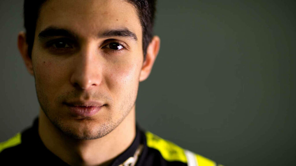 Close-up of Esteban Ocon in detailed racing suit with focused expression Formula 1 wallpaper