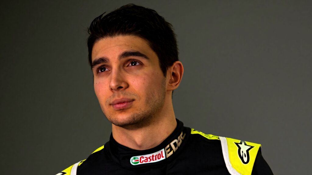 Esteban Ocon portrait in racing suit with sponsor logos on gray background Formula 1 wallpaper