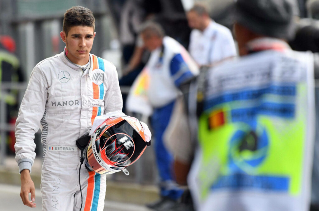 Esteban Ocon in Manor Racing F1 suit holding helmet with determined expression motorsport wallpaper