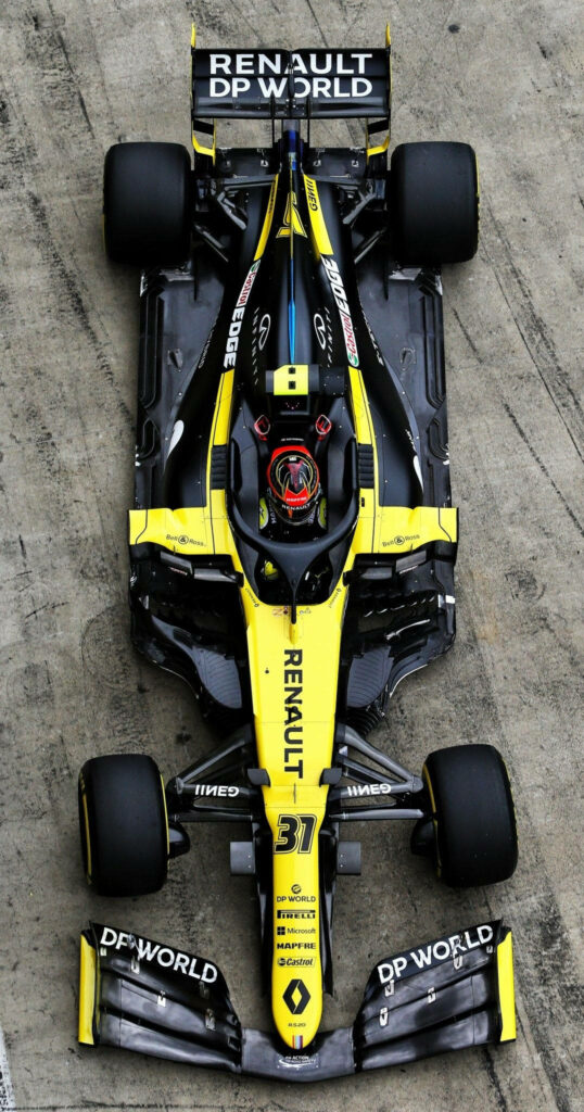 Aerial view of Esteban Ocon Renault DP World F1 car with yellow black livery on race track Wallpaper