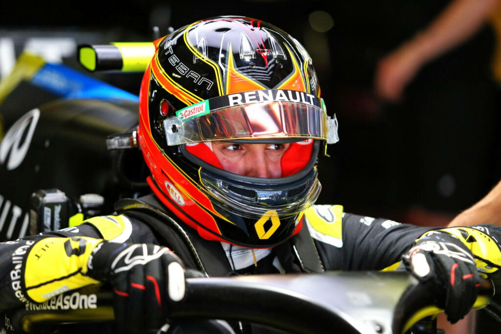 Esteban Ocon Renault F1 driver in racing cockpit with red yellow black helmet and team suit Wallpaper