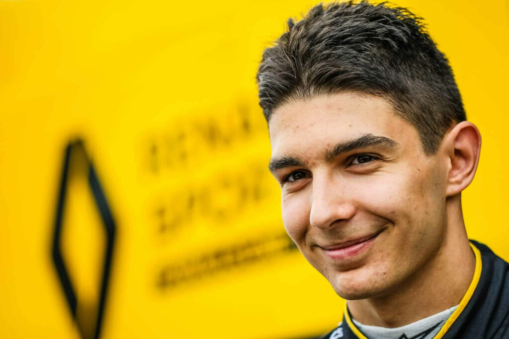 Esteban Ocon confident smile Renault Formula 1 driver vibrant yellow background motorsport wallpaper