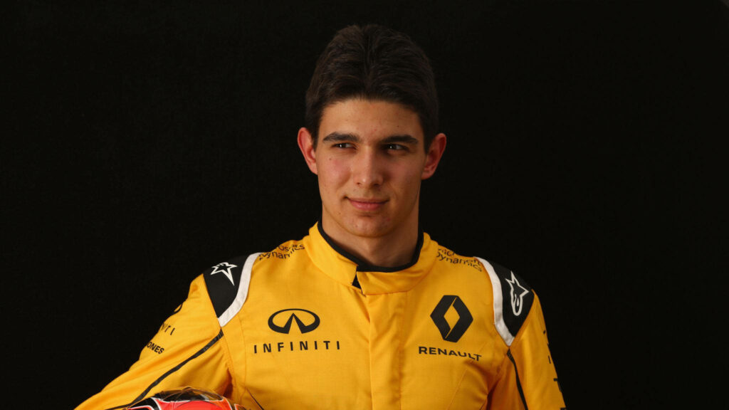 Esteban Ocon in bright yellow Renault suit on black background confident Formula 1 driver wallpaper
