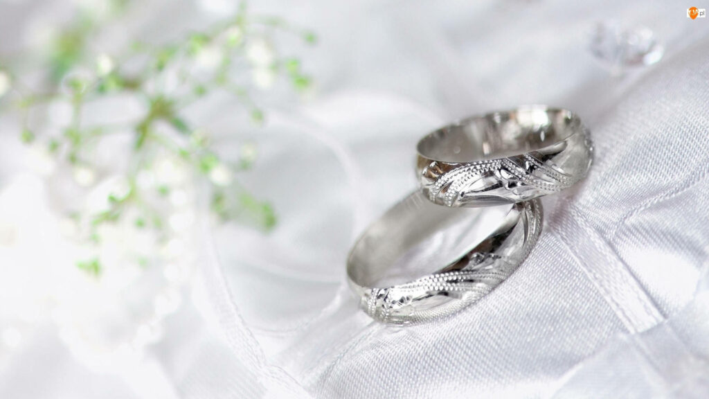 Elegantly Engraved: Mesmerizing Macro Capture of Silvery Wedding Bands on Delicate Cloth Wallpaper