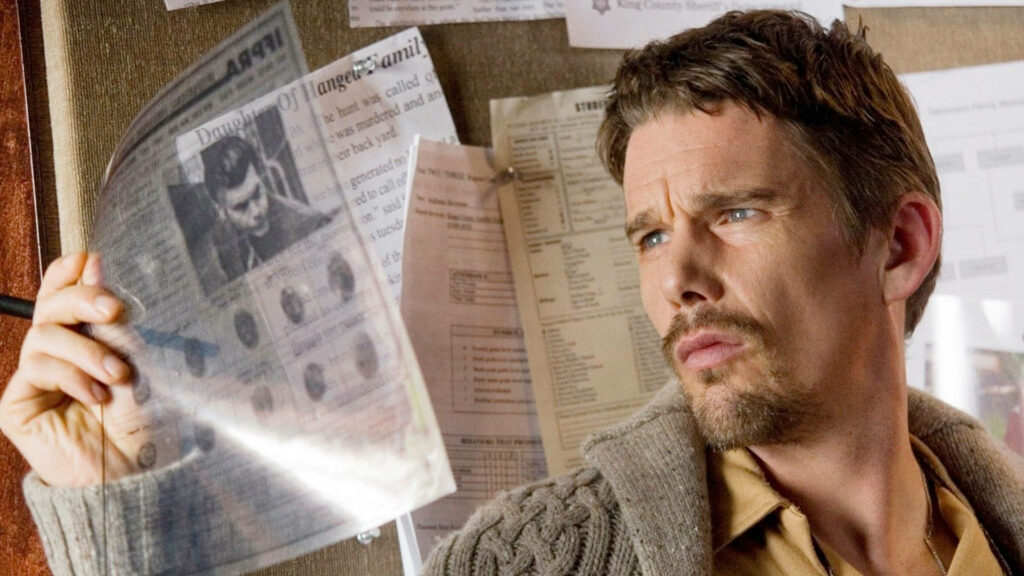Ethan Hawke in Sinister 2012 studying documents on bulletin board in dark suspenseful scene Wallpaper