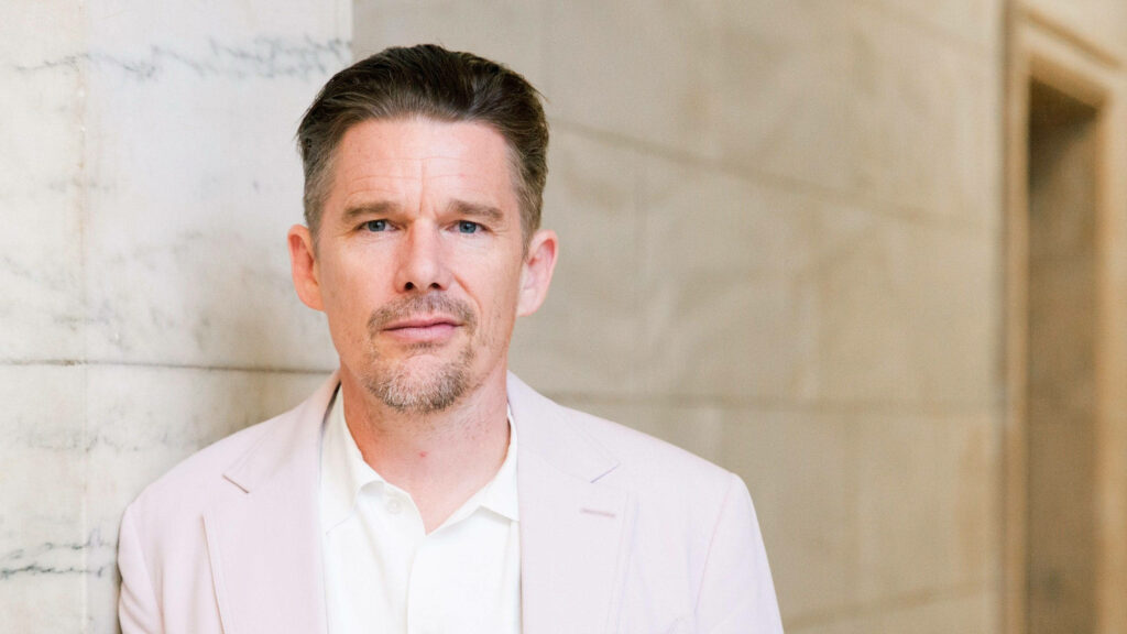 Ethan Hawke stylish portrait in light suit against marble background showcasing calm confidence Wallpaper
