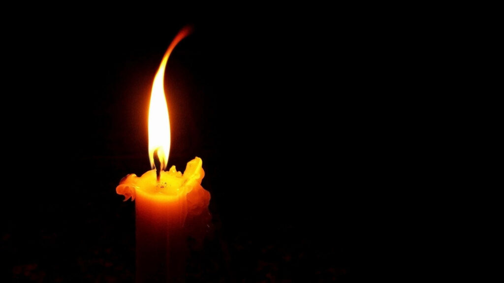 Enchanting Illumination: Captivating Single Candle Casts Striking Glow amid Darkness Wallpaper