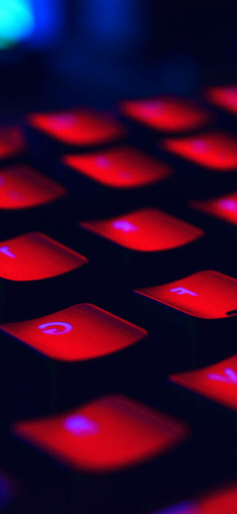 Radiant Scarlet Illumination: Captivating Close-Up of Black Keyboard Enhanced by Monitor's Luminous Glow Wallpaper