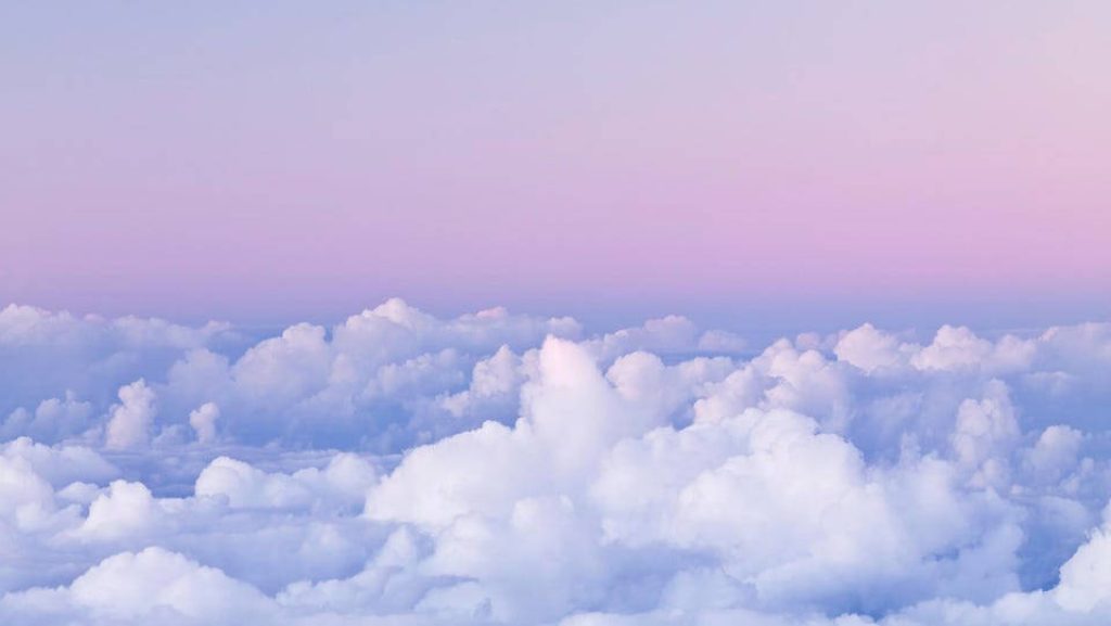 Aerial view of fluffy cumulus clouds with pastel pink and lavender twilight sky wallpaper background