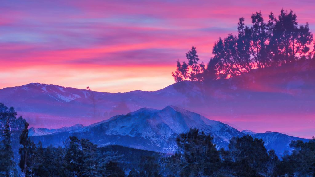 Double-exposure snow-capped mountains pine trees sunset sky purple pink vibrant landscape wallpaper background